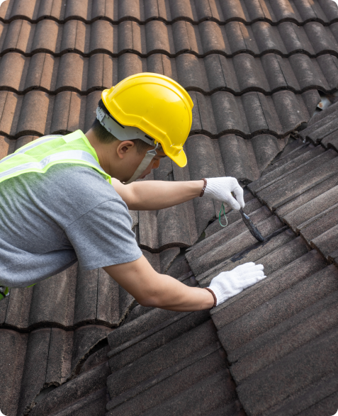 A roofer in Oklahoma City inspecting roof tiles, ensuring high-quality roofing services