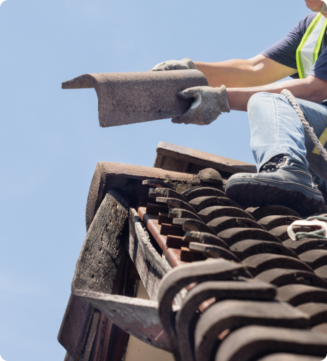 A roofer replacing damaged shingles on a residential roof in Denver, Colorado